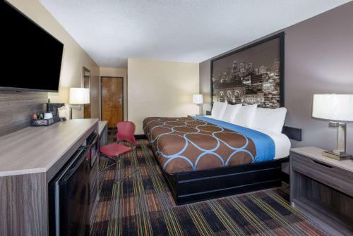 堪萨斯城堪萨斯城巴里路速8汽车旅馆的配有一张床和一台平面电视的酒店客房