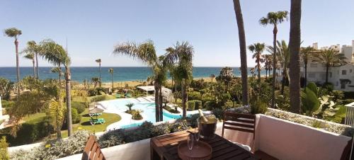 EsteponaEspectacular apartamento primera linea de playa - Golf的享有带游泳池和大海的度假胜地的景致