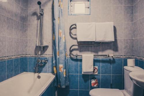 布哈拉明兹法酒店的带浴缸、卫生间和盥洗盆的浴室