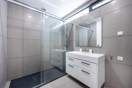 斯代塔维拉Villa Figo的带淋浴、盥洗盆和镜子的浴室