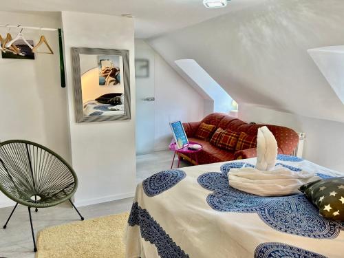 慕尼黑Studio München nahe Olympiapark的客房设有一张带椅子和沙发的床。