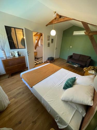 LaburgadeÔ Trois Puits的一间卧室配有一张大床和一张沙发