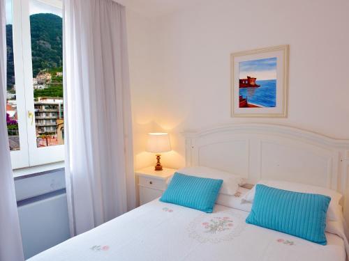 米诺利托雷天堂公寓式酒店的卧室内的白色床和2个蓝色枕头