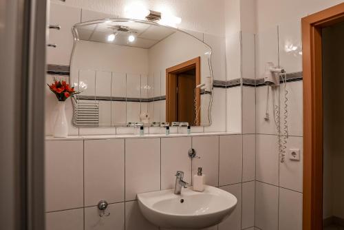 弗伦斯堡Hotel Fruerlund的白色的浴室设有水槽和镜子