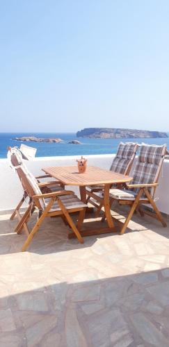 圣玛丽亚Sophia & Chris Studios的一张木桌和两把椅子坐在海边