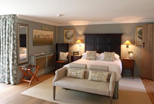亨斯坦顿Luxury Escape的一间卧室配有一张床、一把椅子和镜子