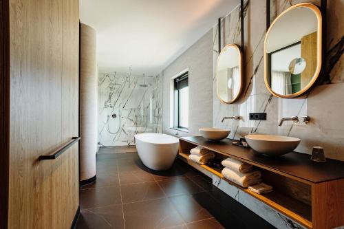 斯希丹Van der Valk Hotel Schiedam的浴室设有2个水槽和2面镜子