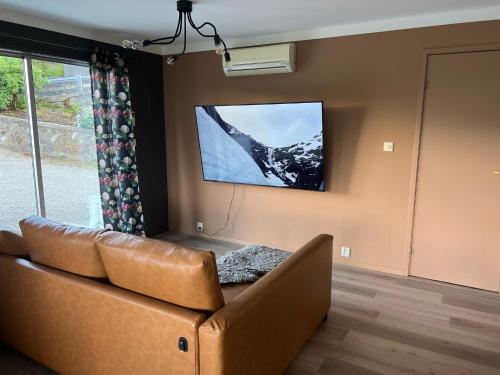 弗莱克菲尤尔Feriehus i Flekkefjord med panoramautsikt的带沙发和平面电视的客厅