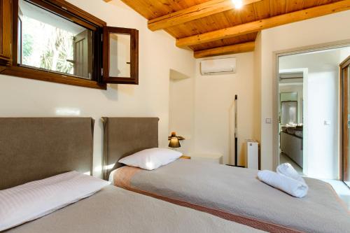 XirokámbionNikolas House的一间卧室设有两张床,墙上设有一面镜子