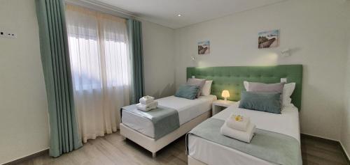 阿尔布费拉Beach View Vela House的一间卧室设有两张床和窗户。