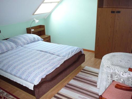 鲍洛通拜雷尼Tilesch Apartment的一间小卧室,配有一张床和一张桌子