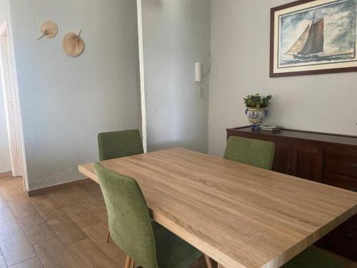 圣玛丽亚港Apartamento Vista Al Mar Calle Ciruela的一间带木桌和绿色椅子的用餐室