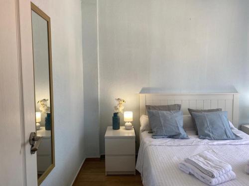 圣玛丽亚港Apartamento Vista Al Mar Calle Ciruela的一间卧室配有一张带蓝色枕头和镜子的床