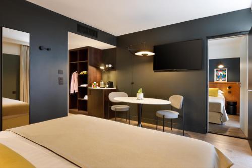 格勒诺布尔RockyPop Grenoble Appartements的一间卧室配有一张床铺和一张桌子,另一间卧室配有一张桌子。