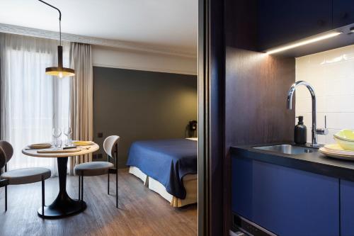格勒诺布尔RockyPop Grenoble Appartements的客房设有床、桌子和水槽