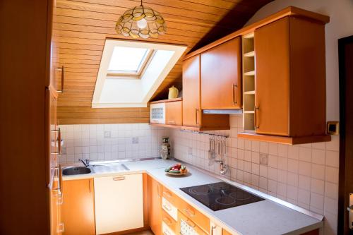 MežicaKamra15的厨房配有木制橱柜、水槽和窗户。