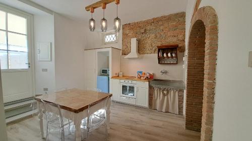 芬奇Casina di Alice的厨房配有桌子和砖墙
