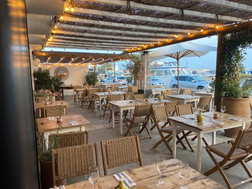 圣马迪拉莫Les Vagues的餐厅设有木桌和椅子及灯