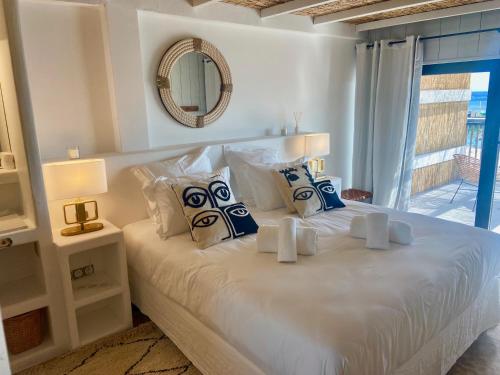 圣马迪拉莫Les Vagues的卧室配有带枕头和镜子的白色床