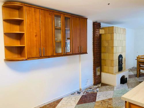 FelsőtoldKontyos Vendégház的厨房配有木制橱柜和瓷砖地板。