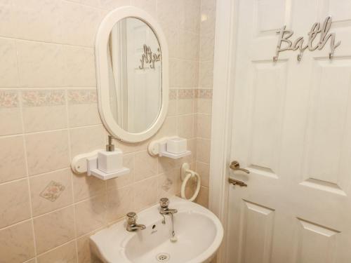 纳伯斯10 Llanteglos Estate的一间带水槽和镜子的浴室