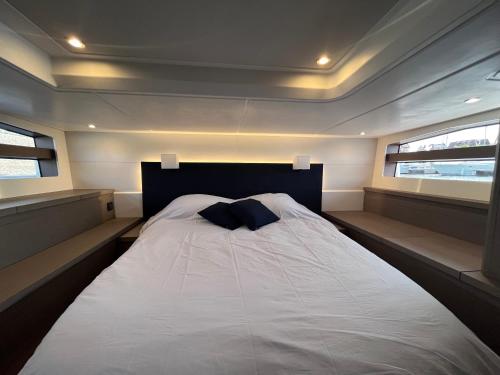 多维尔Puissance, Elegance et Style, Yacht à Deauville的一张位于带2扇窗户的客房中间的床