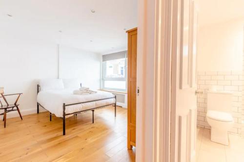 伦敦Spacious 1 Bedroom Apartment in Vibrant Angel的一间卧室配有一张床、一张桌子和一个窗户。