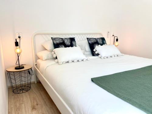 吉亚德伊索拉CASA SOLE - Apartamento Playa San Juan NR. 4的白色的床和黑白枕头