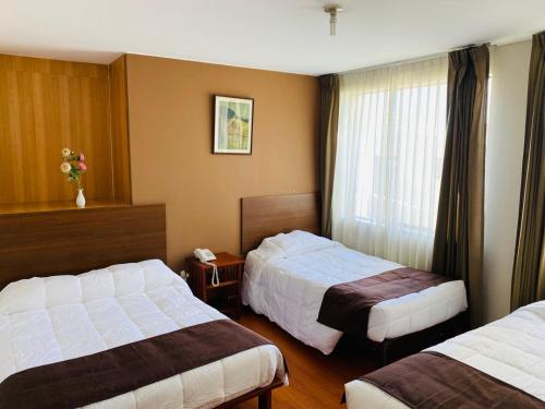 阿雷基帕Helena de Santa María的酒店客房设有两张床和窗户。