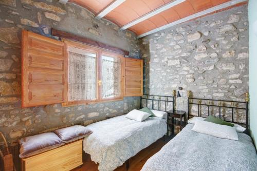 拉波夫拉-德利列特Can MartiPol的一间卧室设有两张床和石墙