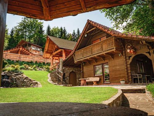 ŻabnicaTworzówka - Ekskluzywne Domy w górach的小木屋设有门廊和庭院