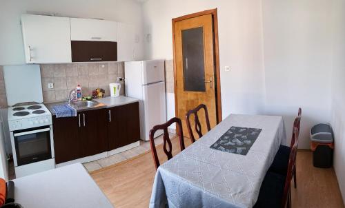 莫斯塔尔Apartment Sunny Bulevar的一个带桌子的小厨房和一个带水槽的厨房