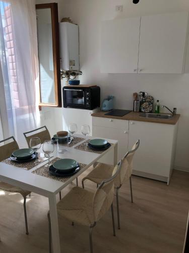 梅斯特Casa Mestrina的厨房配有桌椅、盘子和酒杯