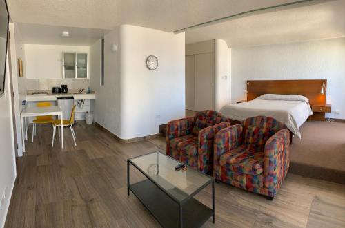 提华纳大理套房酒店的酒店客房配有床、沙发和桌子。