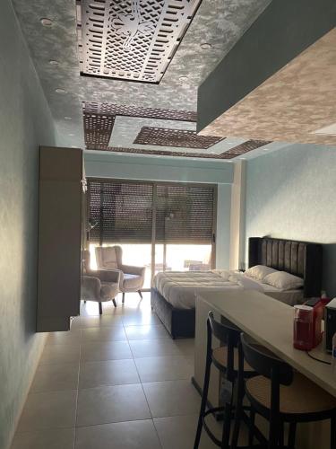 亚喀巴Al Raha Village - Aqaba的卧室配有一张床和一张桌子及椅子