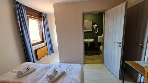ŽirovnicaPension Knafel的一间卧室配有一张床,浴室设有水槽