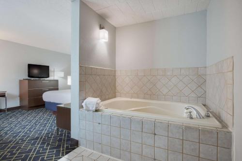 马塔莫罗斯Best Western Hunt's Landing Hotel Matamoras Milford的带浴缸和床的酒店客房