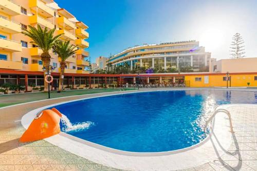 洛斯克里斯蒂亚诺斯Luminoso y bonito apartamento con piscina en frente del mar的大楼内一个带滑梯的游泳池