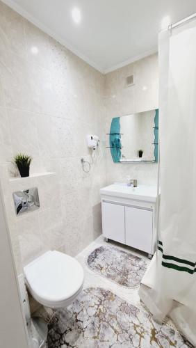 科克舍套1 ком квартира Аблайхана 1的白色的浴室设有卫生间和水槽。