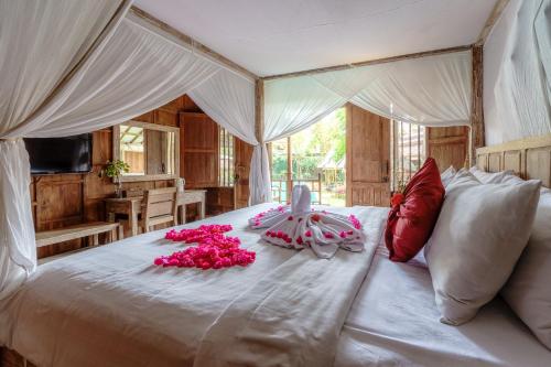 乌鲁瓦图My Dream Bali的一间卧室,床上有粉红色的鲜花