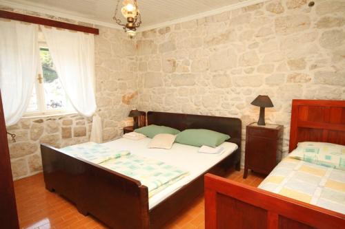 拉斯托伏Seaside holiday house Lucica, Lastovo - 8348的一间卧室设有两张床和石墙