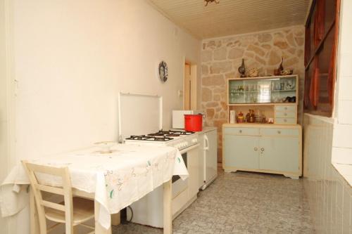拉斯托伏Seaside holiday house Lucica, Lastovo - 8348的厨房配有桌子和炉灶。 顶部烤箱