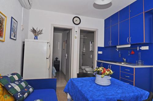 UbliApartments by the sea Pasadur, Lastovo - 8351的厨房配有蓝色橱柜和鲜花桌