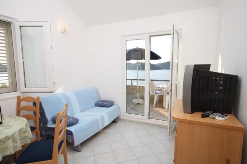 UbliApartments by the sea Ubli, Lastovo - 8355的客厅配有蓝色的沙发和电视