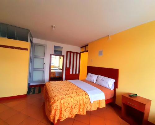 万卡约Hospedaje Las Lilas的一间卧室设有一张黄色墙壁的大床