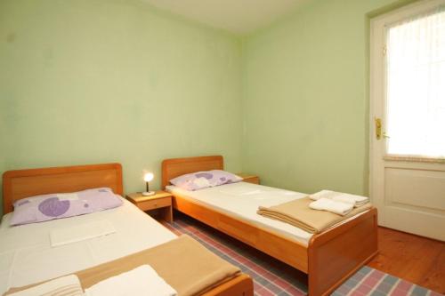 斯拉诺Apartments with a parking space Slano, Dubrovnik - 8547的带窗户的客房内设有两张单人床。