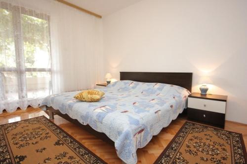 Donje SeloApartments by the sea Muline, Ugljan - 8520的一间卧室配有一张带蓝色被子和两张地毯的床。