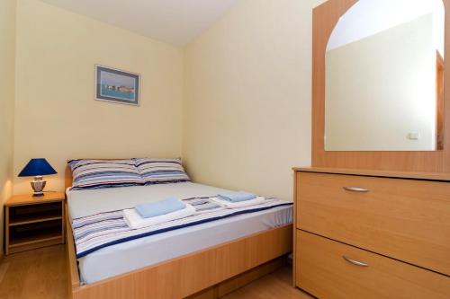 杜布罗夫尼克Apartments with a parking space Dubrovnik - 8593的一间卧室配有一张带梳妆台和镜子的床