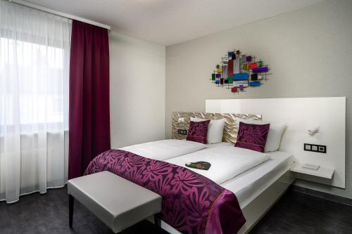 达姆施塔特海德堡城市酒店的卧室配有一张大白色床和紫色床单