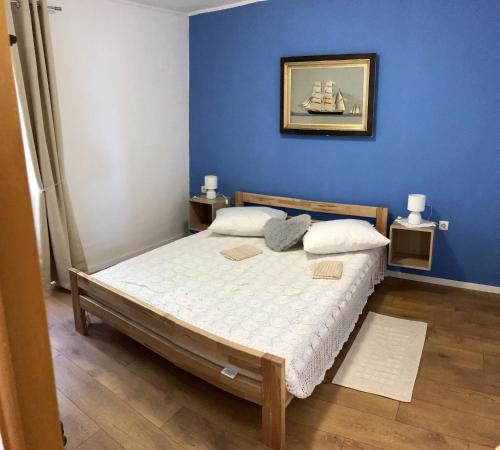 维甘Holiday house with a parking space Viganj - Podac, Peljesac - 10141的一间卧室配有一张蓝色墙壁的床